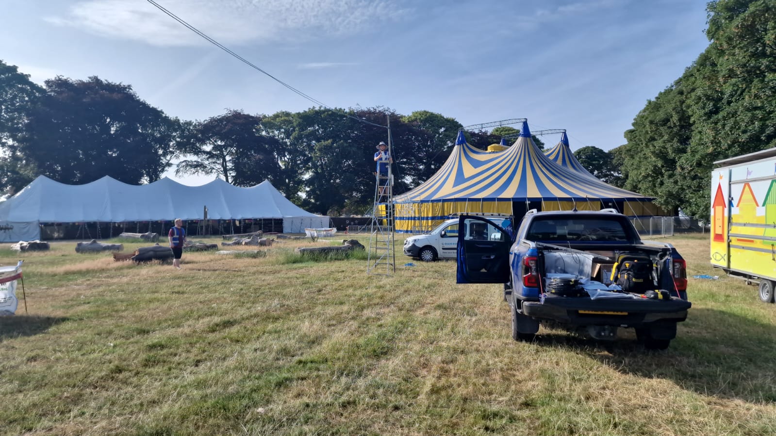 HTG team working on arena infrastructure at Deershed Festival 2026 with the main big top behind